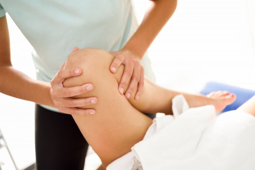 Le spécialiste fait le massage thérapeutique avec l'arthrose du genou